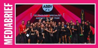 Group of people on stage at an awards ceremony, holding trophies, with 'ABBY' and 'Agency of the Year' on the screen behind them.