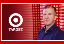 From intern to CEO: Michael Fiddelke’s 22-year journey at Target Smiling man in a blue shirt stands in front of a red backdrop featuring the Target logo, with ‘MEDIABRIEF’ written vertically along the left edge.